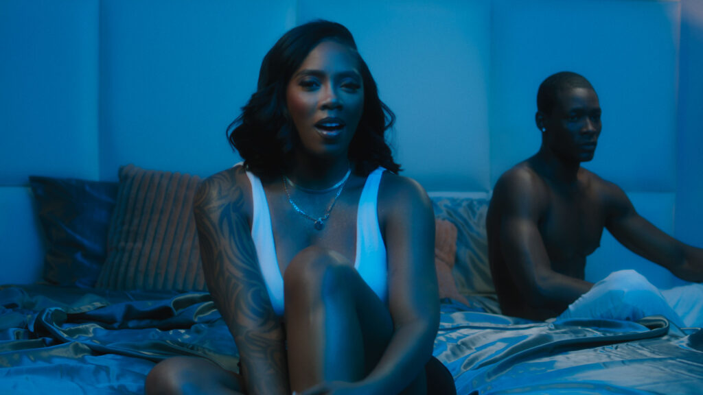 Color grading example. Black woman on brown bed, illuminated by warm and blue light. Blue look